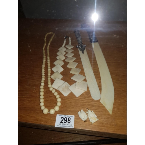 298 - Two ivory page turners with silver handles, bone and ivory bead necklaces and two pendants