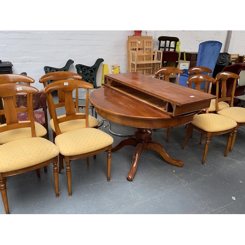 543 - An extending circular dining table with eight chairs and two extra leaves