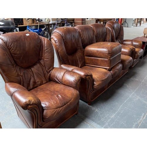 554 - A leather three seater sofa, two matching armchairs and a footstool