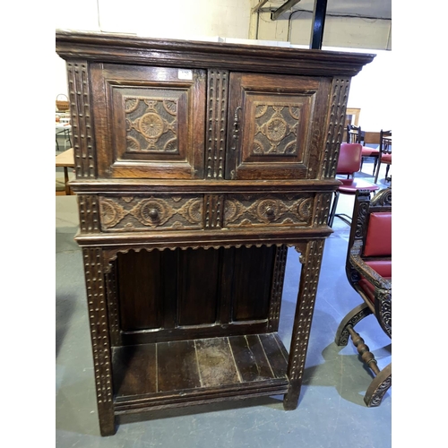 129 - An early heavily carved oak tall cabinet with two doors and two drawers