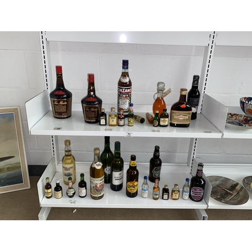 71 - A collection of alcohol including Tia Maria, Cinzano, Drambuie, miniatures etc - 2 shelves