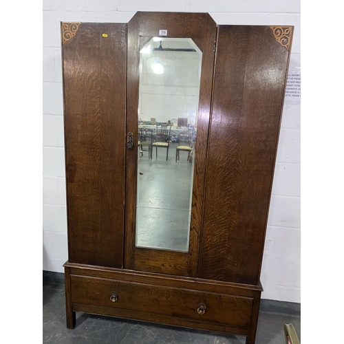 116 - An oak wardrobe with mirrored door and single drawer
