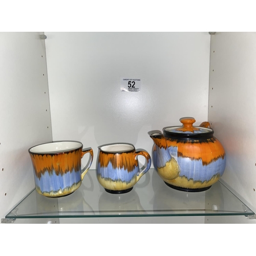 52 - A 1930's Arthur Woods teapot (damage to the spout), a jug and a cup