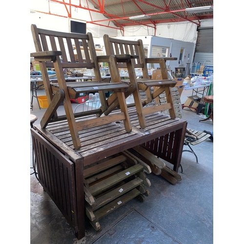 332 - A teak garden table and chairs plus folding teak chairs