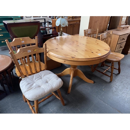 547 - An extending circular pine dining table and four chairs