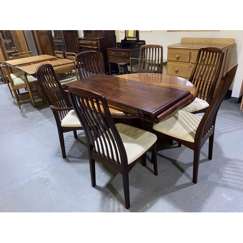 125 - A Svegards circular Rosewood extending dining table and six matching Rosewood dining chairs includin... 