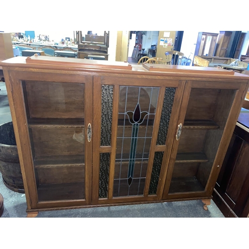 135 - An oak Edwardian glass fronted bookcase with stained glass panels