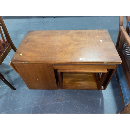 165 - A mid century teak coffee table with fold over top housing a nest of tables and storage