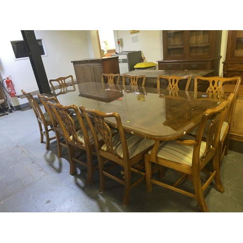 128 - An extending burr walnut glass top dining table with two extra leaves and ten chairs