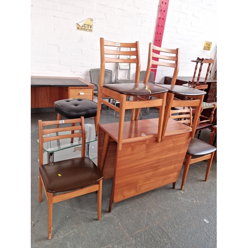 528 - A retro teak drop leaf dining table and four chairs