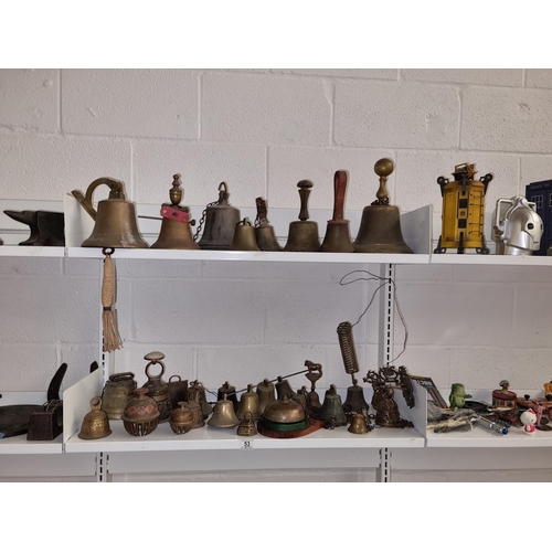53 - A collection of brass school bells, shop bells etc. - 2 shelves