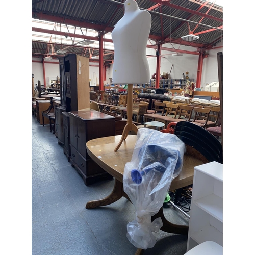 544 - A oak extending dining table and two seamstress mannequins