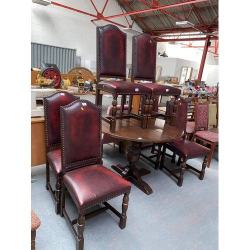 575 - Oak extending dining table and six red leather oak framed chairs