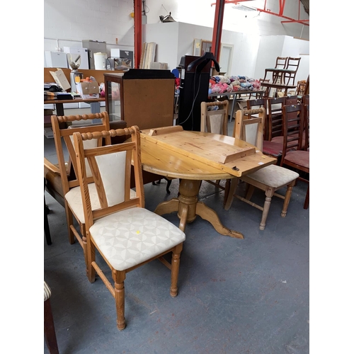 577 - An extending pine circular dining table and four chairs