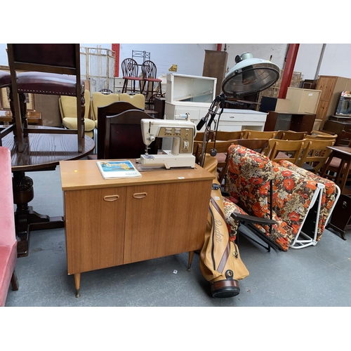 583 - A Singer sewing machine with cupboard, a retro lamp, golf clubs and two sun loungers