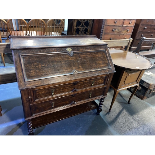 131 - An oak writing bureau and a curiosity cabinet with pie crust swivel top