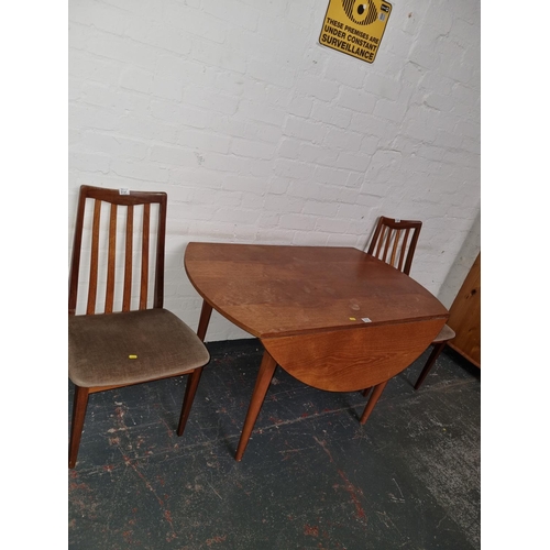 310 - A teak drop leaf dining table and two G Plan teak chairs