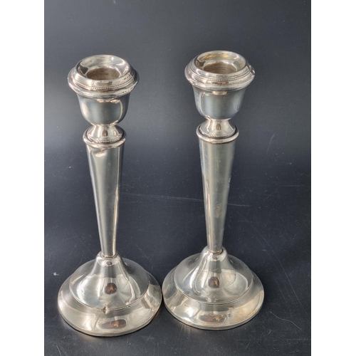 285 - A pair of hallmarked silver weighted candlesticks - measuring 8 inches tall