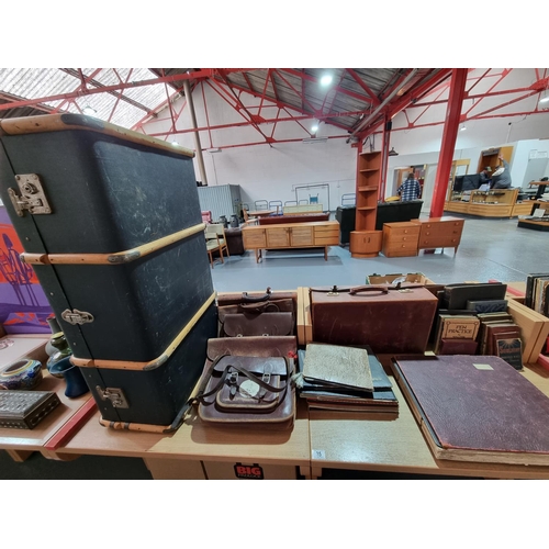 35 - A wooden bound travel trunk, leather satchels, postcards and photograph albums and a salary/wages le... 