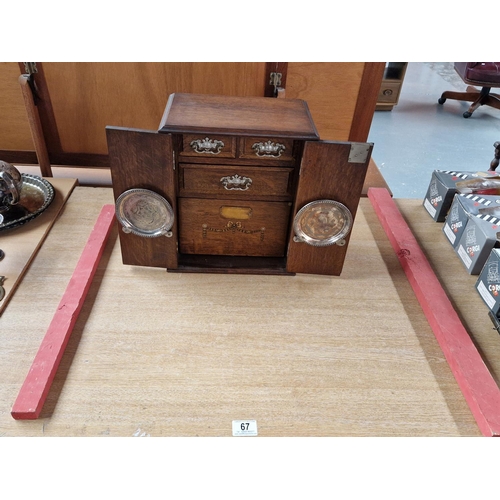 67 - An oak smokers cabinet with fitted interior and tobacco jar