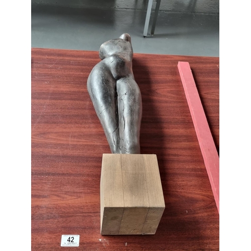 42 - A terracotta sculpture of female form on a wooden plinth