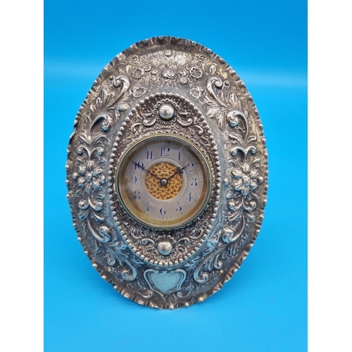 207 - A hallmarked silver clock frame and clock - floral Repoussé design - London hallmarks (9 inches tall... 