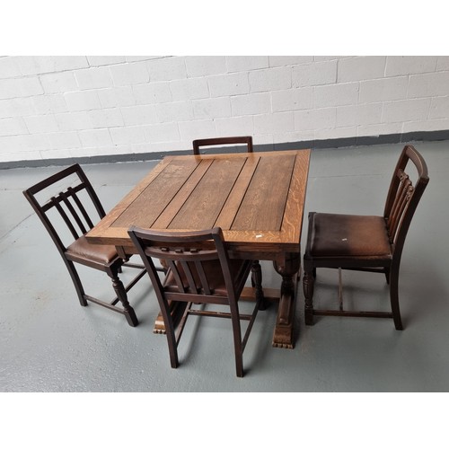 135 - An oak draw leaf dining table and four chairs