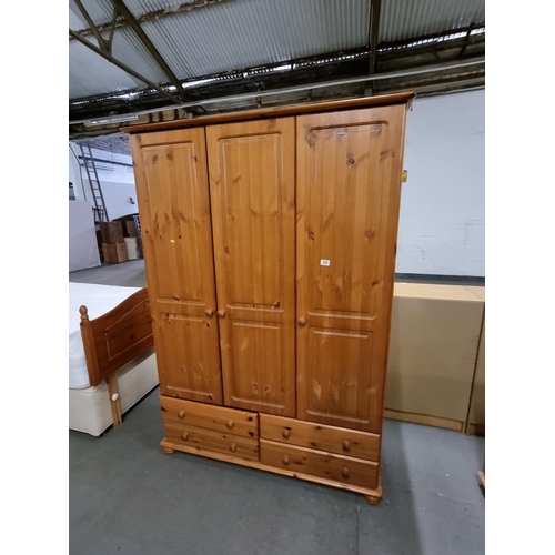 395 - A 3 door pine wardrobe with 4 drawers