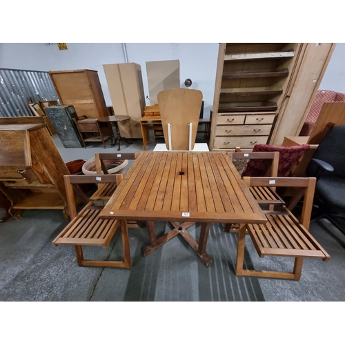 567 - A teak garden table and 4 matching folding chairs