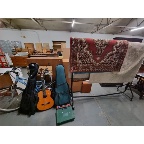 606 - 4 x rugs, 3 x guitars, a Shockwave pedal bike, a workmate, tile cutter, etc