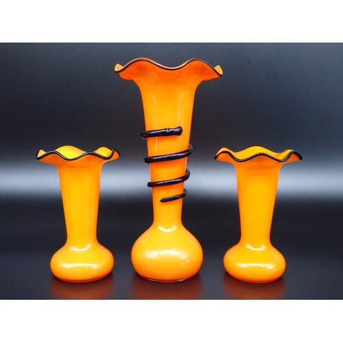 17 - Czech Art Deco, a garniture set consisting of thee orange and black glass Tango vases, largest with ... 