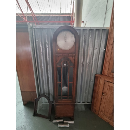 136 - An oak cased Grandfather clock with weights and pendulum