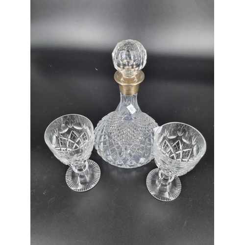 206 - A crystal decanter with a hallmarked silver collar and a pair of crystal glasses