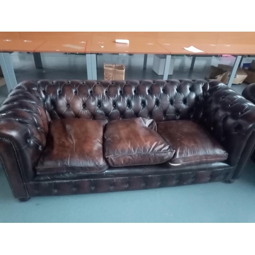 110 - A brown leather Chesterfield three seater sofa