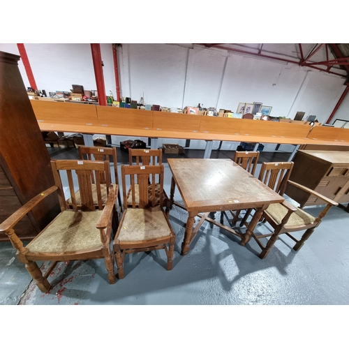 107 - An oak draw leaf dining table and six chairs to include two carvers