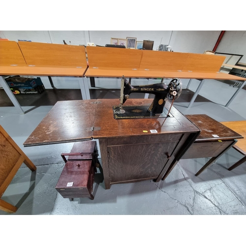 109 - A Singer sewing machine with cabinet and two sewing boxes with contents