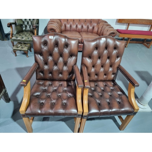 142 - Two brown leather Chesterfield armchairs