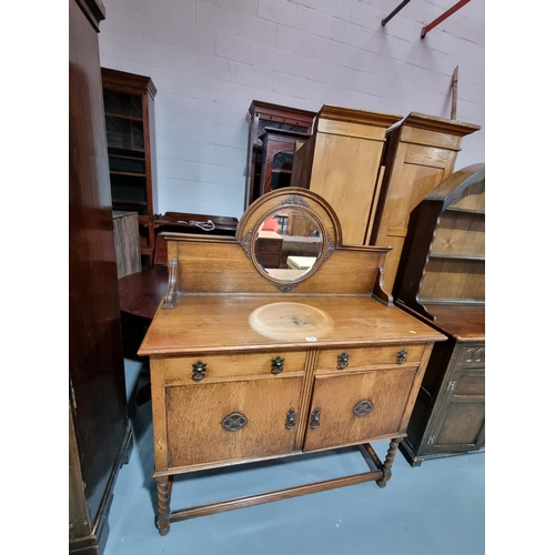 154 - An oak mirrored back sideboard