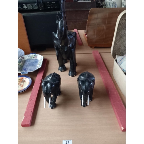 42 - A large carved trumpeting ebony elephant and a pair of smaller elephants