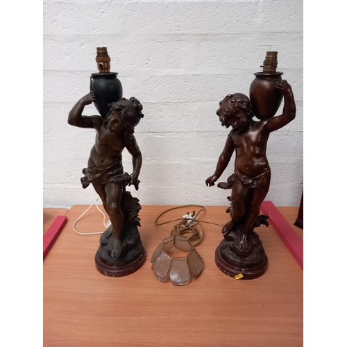 10 - Two large spelter lamps - young female and male carrying urns - damage to the males arm
