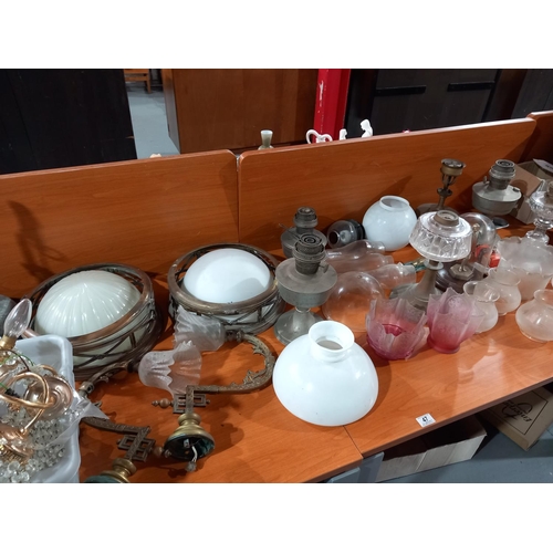 47 - A collection of oil lamps, shades, brass wall lights, chandelier and lamp parts
