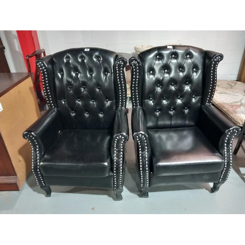 148 - Two black leather chesterfield style armchairs