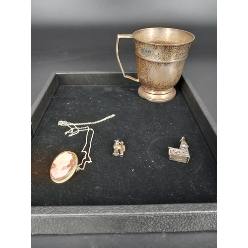 224 - A hallmarked silver christening mug, two silver charms and a silver cameo pendant on silver chain (c... 