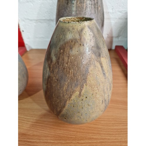 4 - A tall studio pottery vase (17 inches high) and a pair of matching smaller vases (10 inches high) si... 