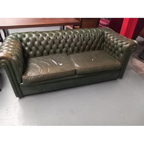 134 - A green leather Chesterfield two seater sofa