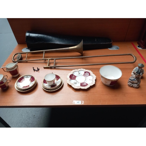 44 - A brass trombone with case (case damaged and trombone missing the mouthpiece), a pretty part tea set... 