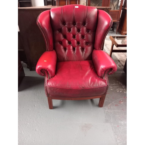 121 - A red leather Chesterfield wingback armchair