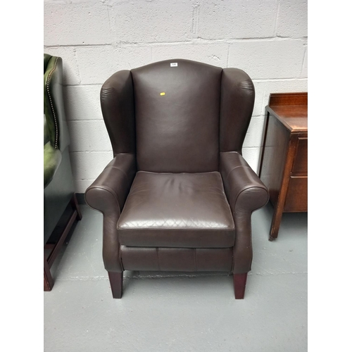 148 - A brown leather wingback armchair