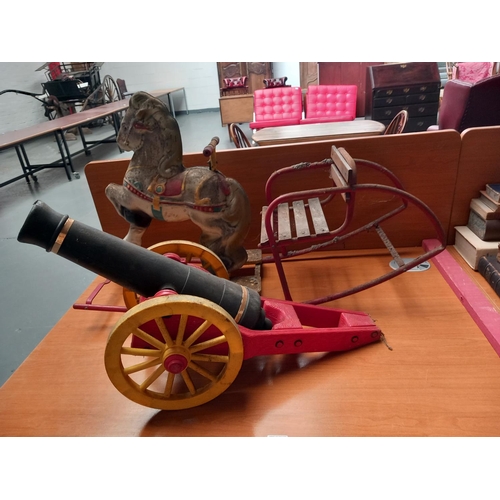 44 - A vintage tin rocking horse and a cannon