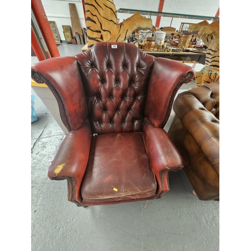 106 - A red leather Chesterfield wingback armchair